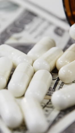 lots of dollar bank notes scattered with pills on table