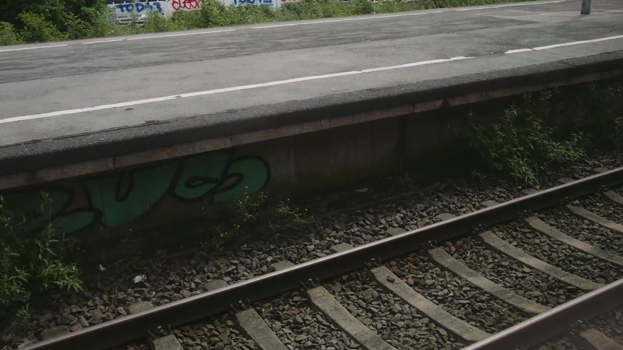 Treno in fermata alla stazione, binari, primo piano medio