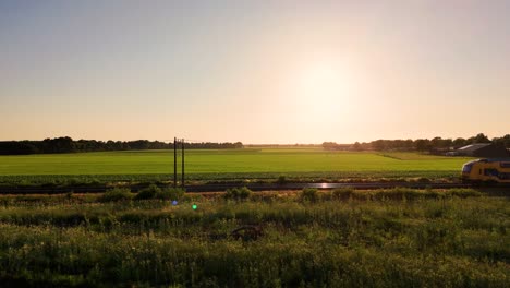 train in rural dutch landscape at sunset