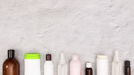 bottiglie di cosmetici per la cura della pelle appaiono sul fondo. stop motion