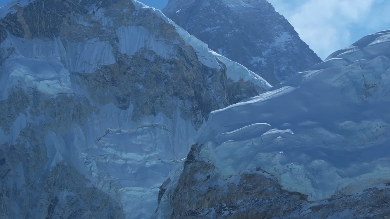 Close-up Drone view of Khumbu Glacier in Nepal’s Everest region, rocky climbing trails, dense snow-capped mountains, sunny weather, need for glacier and environmental protection Tourism aspect