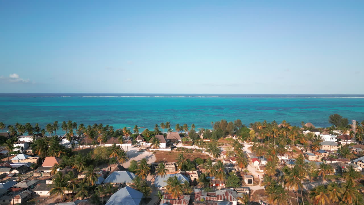 열대 해안 마을은 종려나무와  ⁇  지붕 구조로,  ⁇ 은 파란 하늘 아래 평화로운 투르코이즈 바다와 접한다