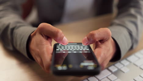 person texting on smartphone at a desk