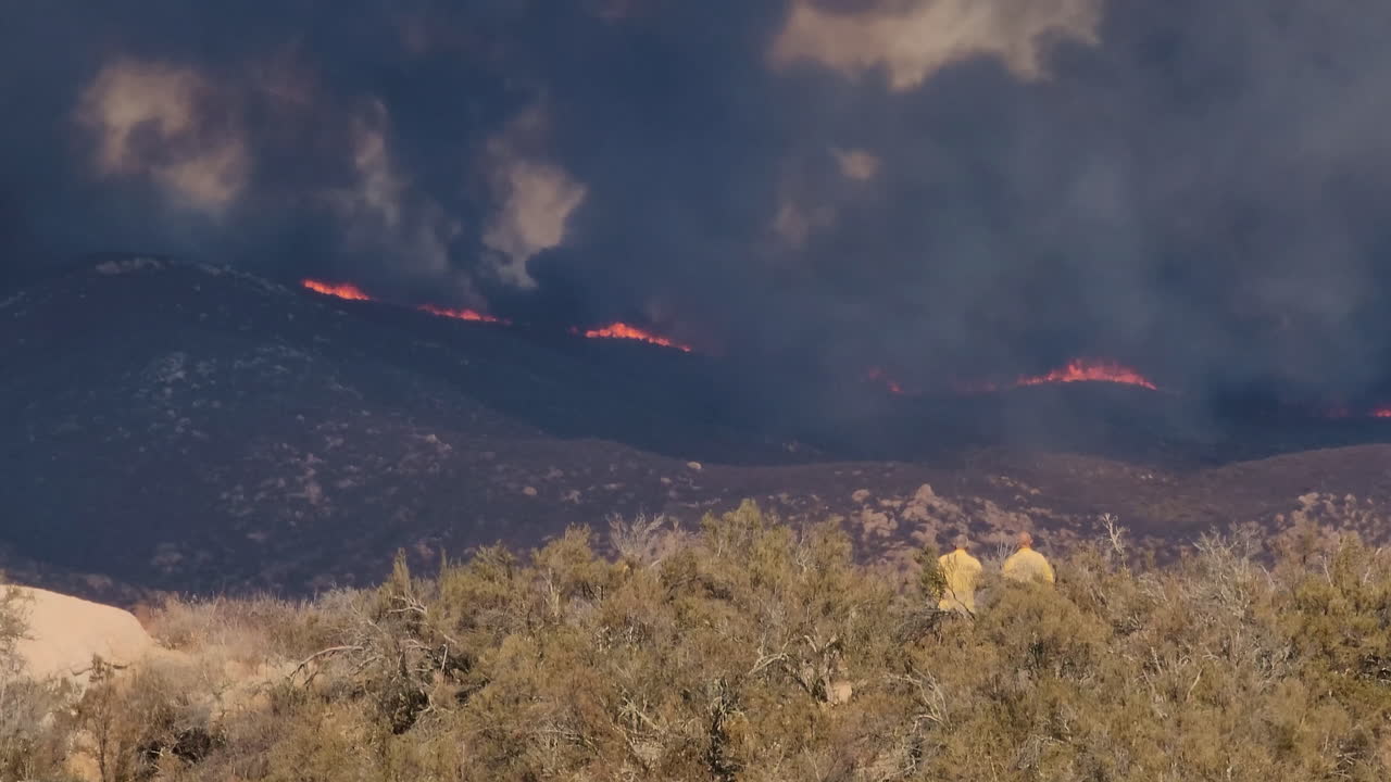 panorámica sobre un aterrador paisaje en llamas en las montañas secas