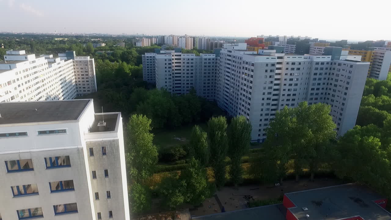 Un dron desciende a lo largo de un edificio residencial blanco al amanecer en Alemania