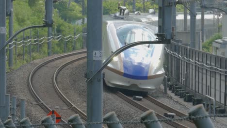 hokuriku shinkansen leaving karuizawa station on its way towards tokyo on a hot summer day