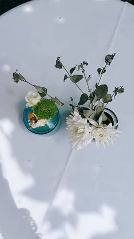 white and green floral arrangement in teal vases