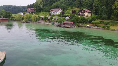 beautiful aerial shot, attersee lake, boat, waterfront houses and trees, austria