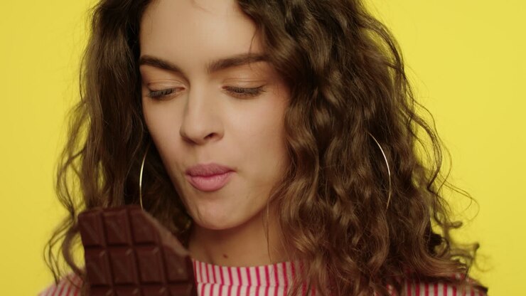 Donna felice che si gode una tavoletta di cioccolato
