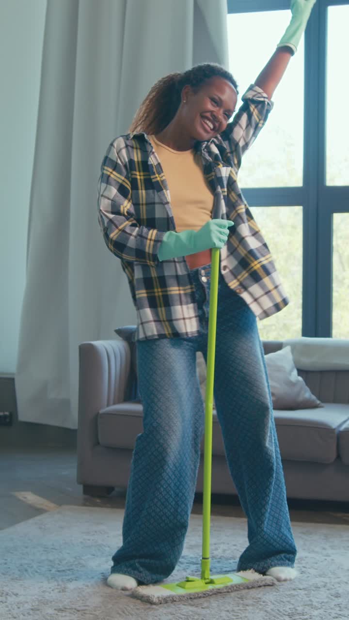 Enjoying cleaning while dancing in a bright living room