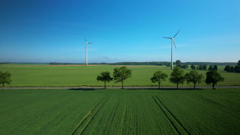 Vista-Aérea-De-Turbinas-Eólicas-En-Campo-Verde,-Movimiento-Panorámico-De-Izquierda-A-Derecha