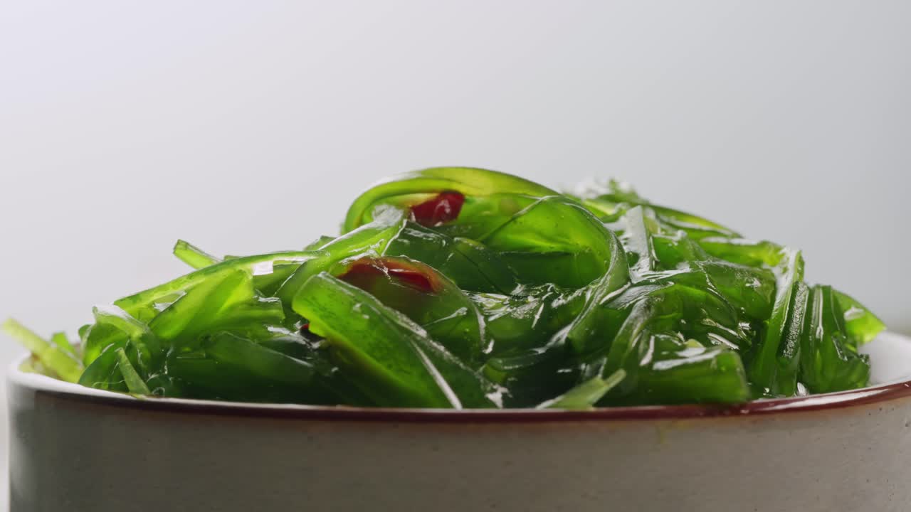 Japanese wakame chuka fermented food. Close-up on a detail of Hiyashi Wakame Chuka or seaweed salad or seaweed with sesame seeds on a plate. Top view. Seafood background. Health concept.