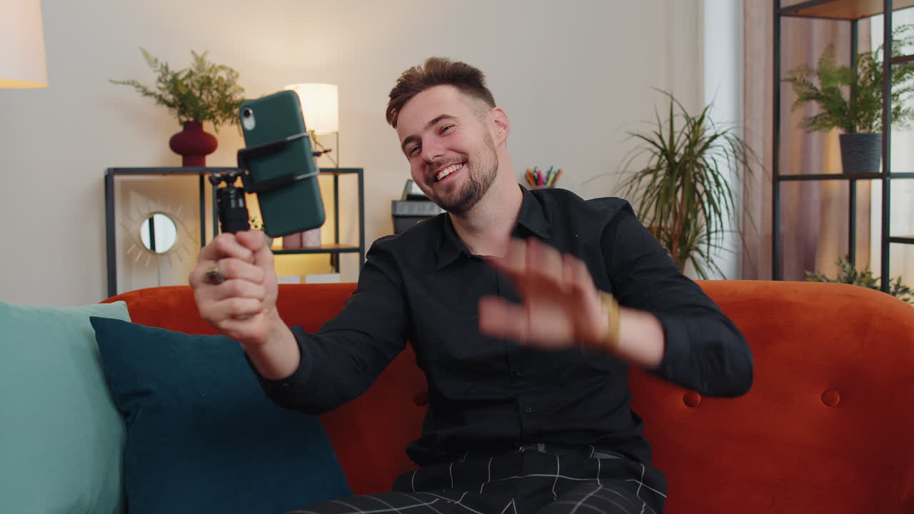 hombre blogger influencer tomando selfie en teléfono inteligente, hacer video virtual de redes sociales en línea en casa