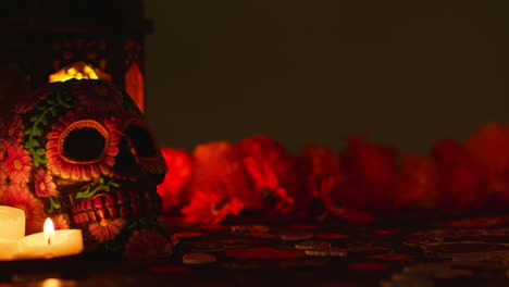 still life of decorated skull with candles and flowers celebrating mexican holiday of dia de muertos or day of the dead