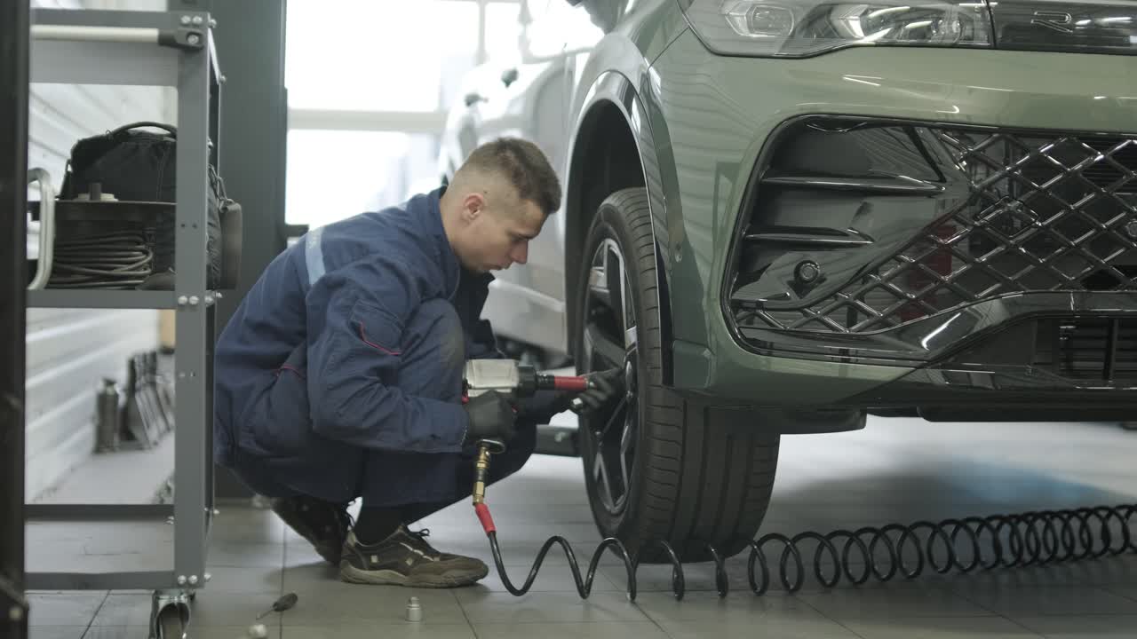 Car mechanic working on tire repair in garage
