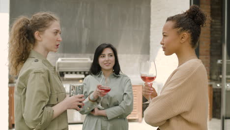 Un-Agradable-Grupo-Multicultural-De-Tres-Chicas-Brinda-Con-Sus-Copas-En-Una-Barbacoa-En-La-Terraza-De-Una-Casa