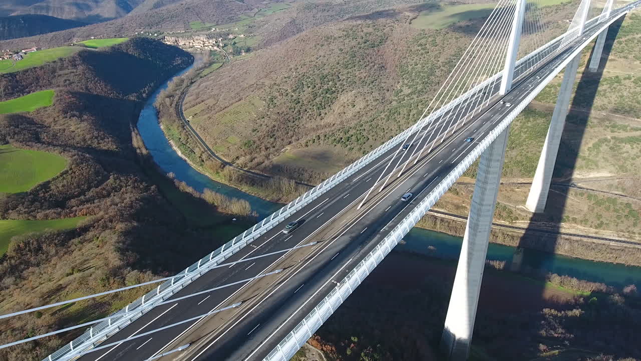 volando hacia el viaducto de millau sobre el río tarn día soleado. disparo de dron aéreo