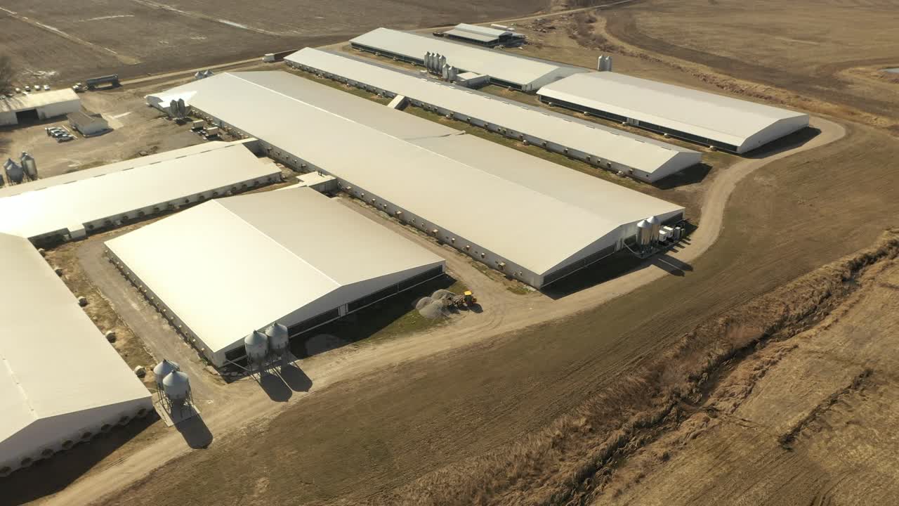 disparo de drones de una granja de confinamiento de cerdos en illinois con un trabajador conduciendo un cargador deslizante