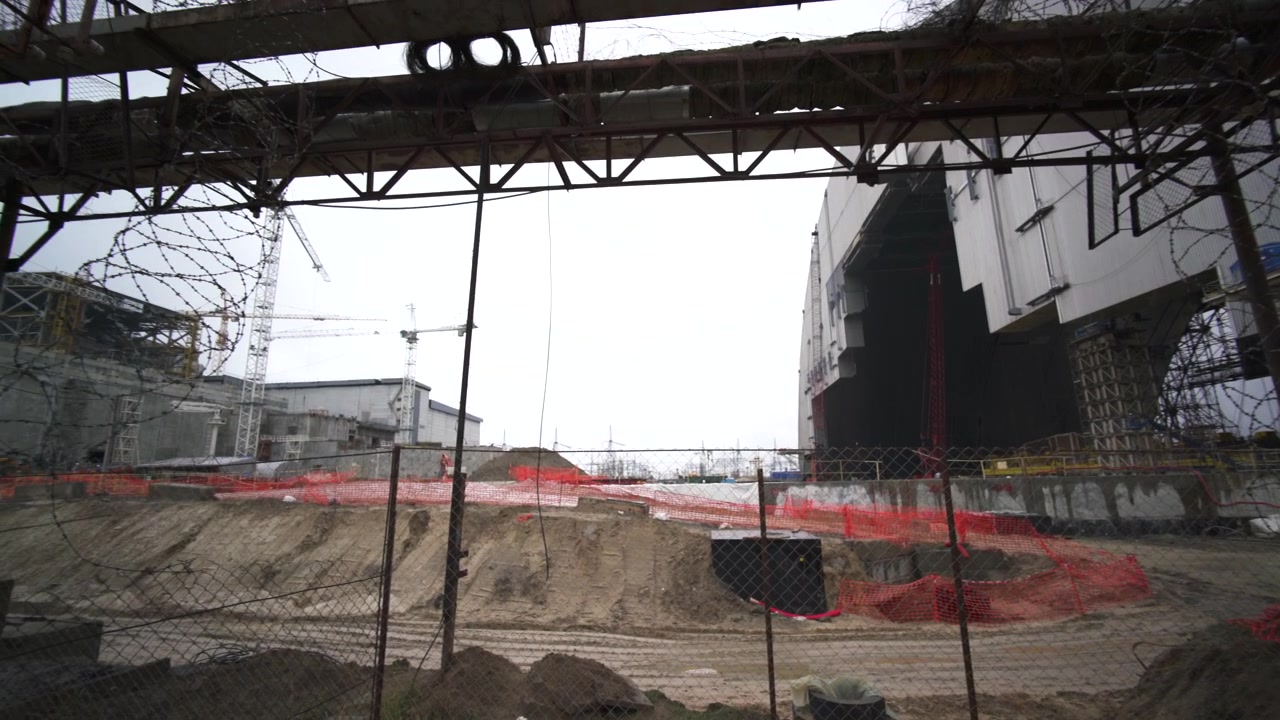Eine Kamera schwenkt über die Baustelle des New Safe Confinement in Tschernobyl