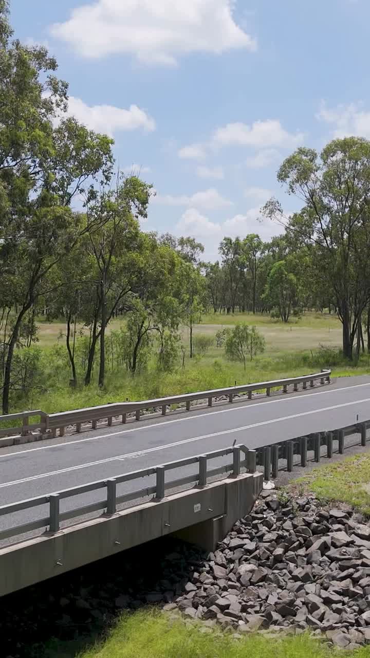 울창 한 오스트레일리아 풍경 에서 차량 이 다리 를 건너는 것