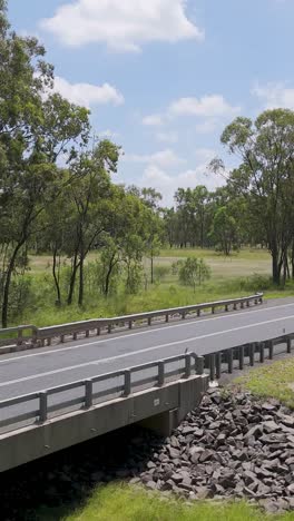 vehicle crossing bridge in lush australian landscape