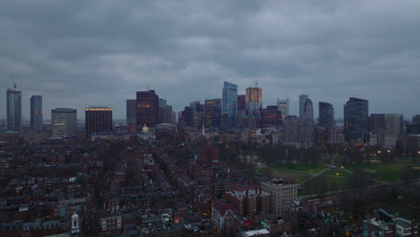 Cinematic-footage-of-cityscape-at-dusk.-Residential-urban-borough,-public-park-and-downtown-skyscrapers-in-background.-Boston,-USA