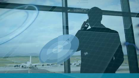 animation of data processing against rear view of a businessman talking on smartphone at an airport