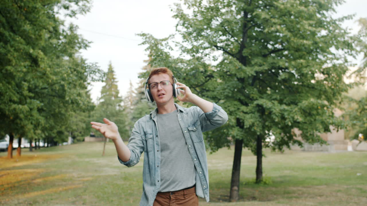 Man listening to music and dancing in a park