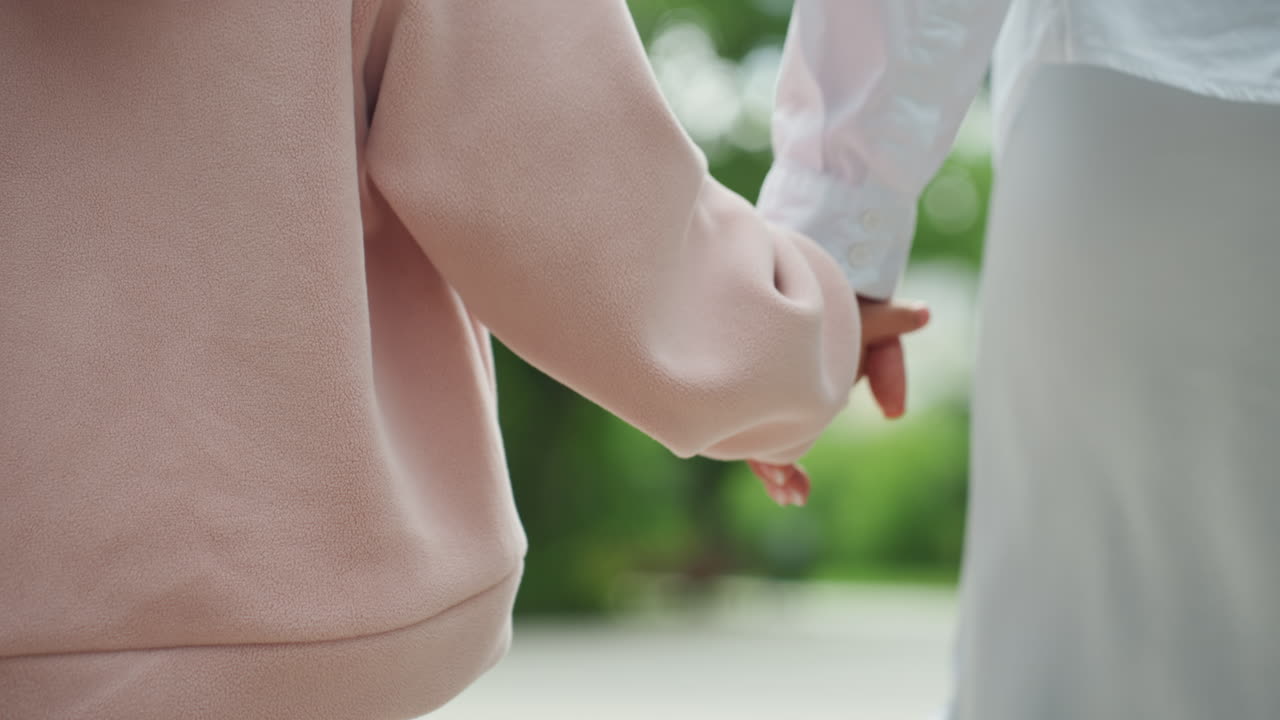 親が幼い探検家を屋外で案内する。子供と母親が一緒に森林の小道を歩く。母親と幼い娘が、静かに注意深く、風光明媚な森林の小道を一緒に進む。