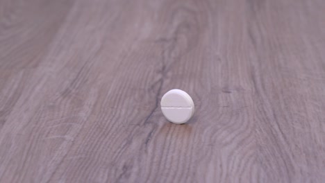 large white tablet rolls along the surface of table or floor. refusal from daily regular intake of drugs on schedule, neglect of personal health.