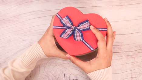 heart-shaped gift box in hands