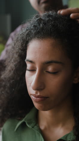 woman with curly hair getting her hair styled