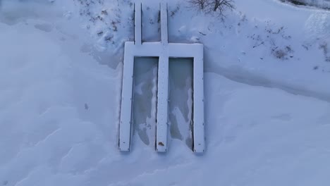 Aerial-of-women-looking-up-towards-camera-on-a-dock-on-a-winter-snowy-day