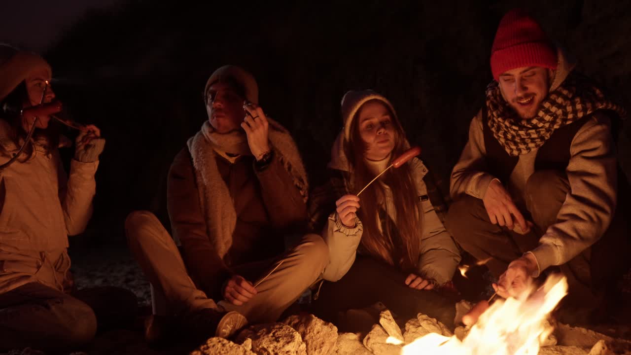 친구 들 이 밤 에 캠프 불 을 즐기고 있다