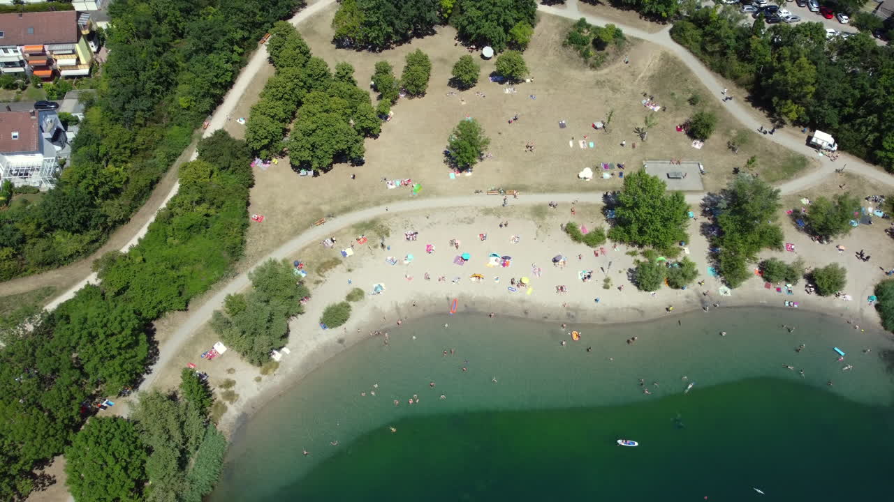 Aerial view of a lake with people enjoying the summer day in a park