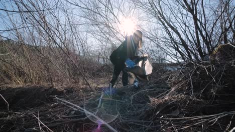 teamwork cleaning plastic on the beach. volunteers collect trash in a trash bag. plastic pollution and environmental problem concept. voluntary cleaning of nature from plastic. greening the planet