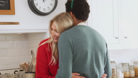 loving couple wearing fancy dress antlers dancing in kitchen whilst preparing christmas dinner