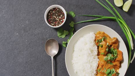 video of plate with rice and curry with pepper lying in grey background