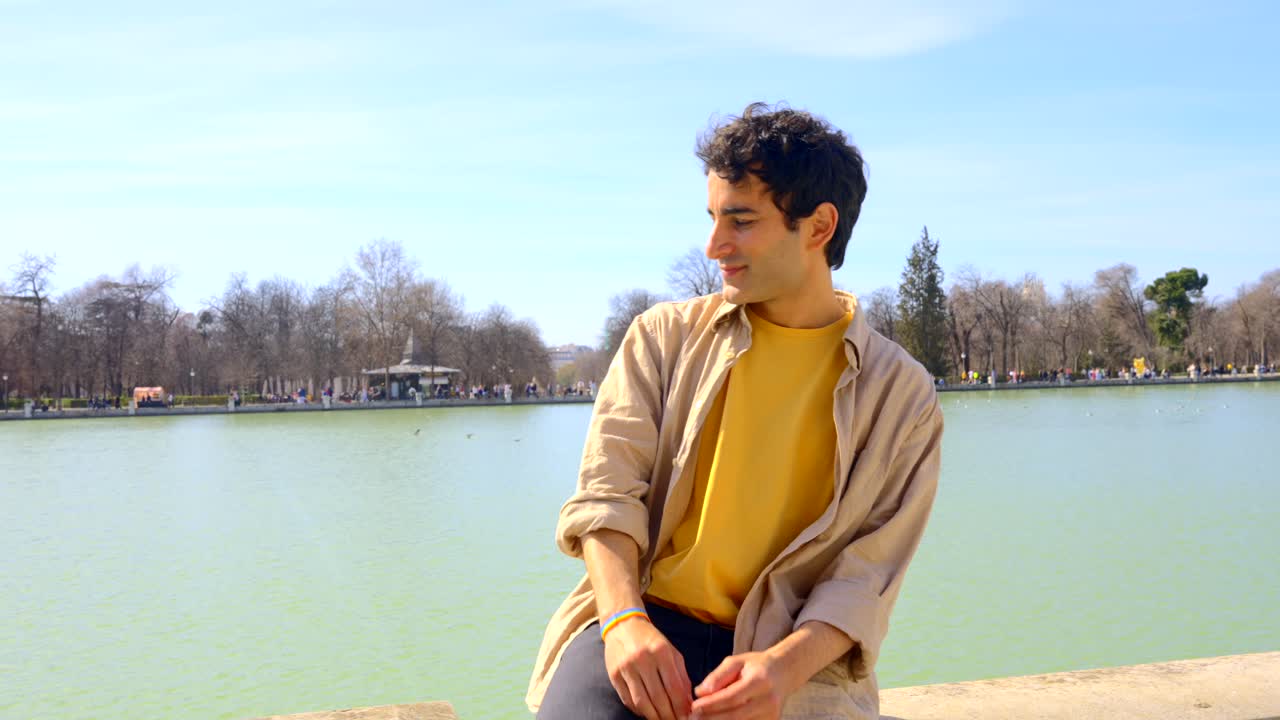 Man Relaxing by the Lake in a Park