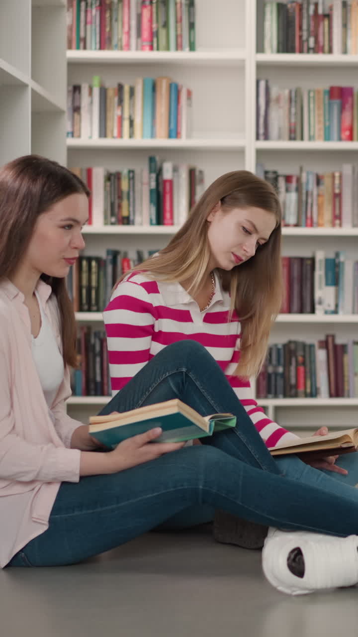 grupo de amigos estudia materiales en la biblioteca. hombre negro positivo con mujeres lleva a cabo una reunión informal del club de lectura en la librería. estudiantes leen libros