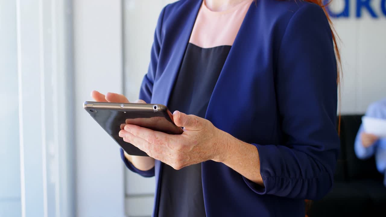 mujer de negocios usando tableta digital en la oficina 4k