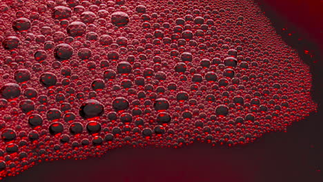 foamy alcoholic drink surface top view. wine bubbles bursting slowly closeup