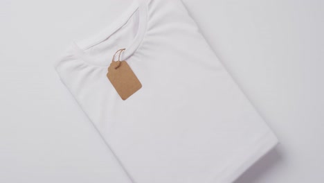 video of white folded t shirt with tag and copy space on white background