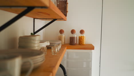 shelf with kitchen utensils in glamping hotel room. household goods on well-organized wooden shelves for comfortable stay. available to use for guests