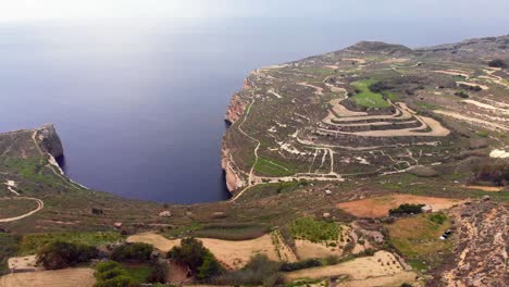 Video-épico-De-Drones-Aéreos-Ascendentes-De-La-Zona-Rural-Occidental-De-Malta,-Que-Incluye-El-Paisaje-Y-Las-Tierras-Altas-Con-La-Asombrosa-Bahía-Y-El-Mar-Mediterráneo-Al-Fondo