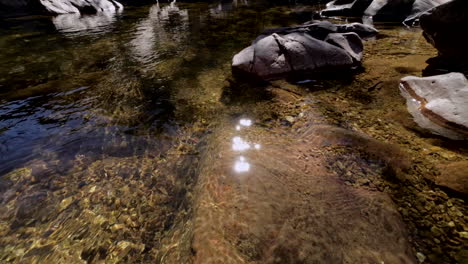 Boom-down-towards-a-fresh-water-stream-and-sunlight-sparkling-on-the-surface-of-the-water