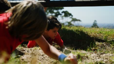 kids crawling under the net during obstacle course training