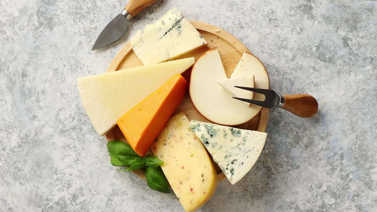 소박한 나무 보드에 제공되는 다양한 종류의 치즈