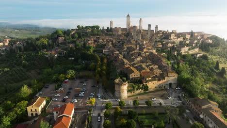 aerial panoramic view over san gimignano during foggy early morning in siena, tuscany, north-central italy