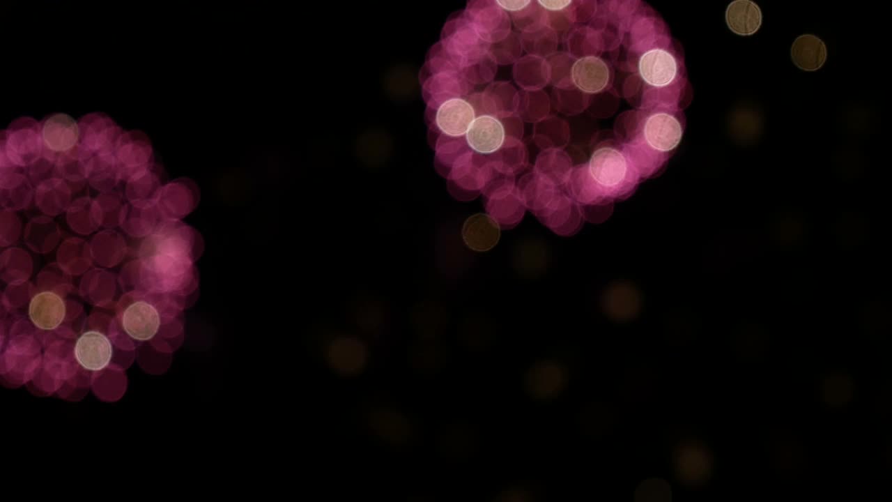 4K. Sømløs loop nærbilde av ekte fyrverkeribakgrunn. Abstrakt uskarphet av ekte gyllent skinnende fyrverkeri med bokeh-lys på nattehimmelen. Glødende fyrverkerishow. Nyttårsaften fyrverkerifeiring.